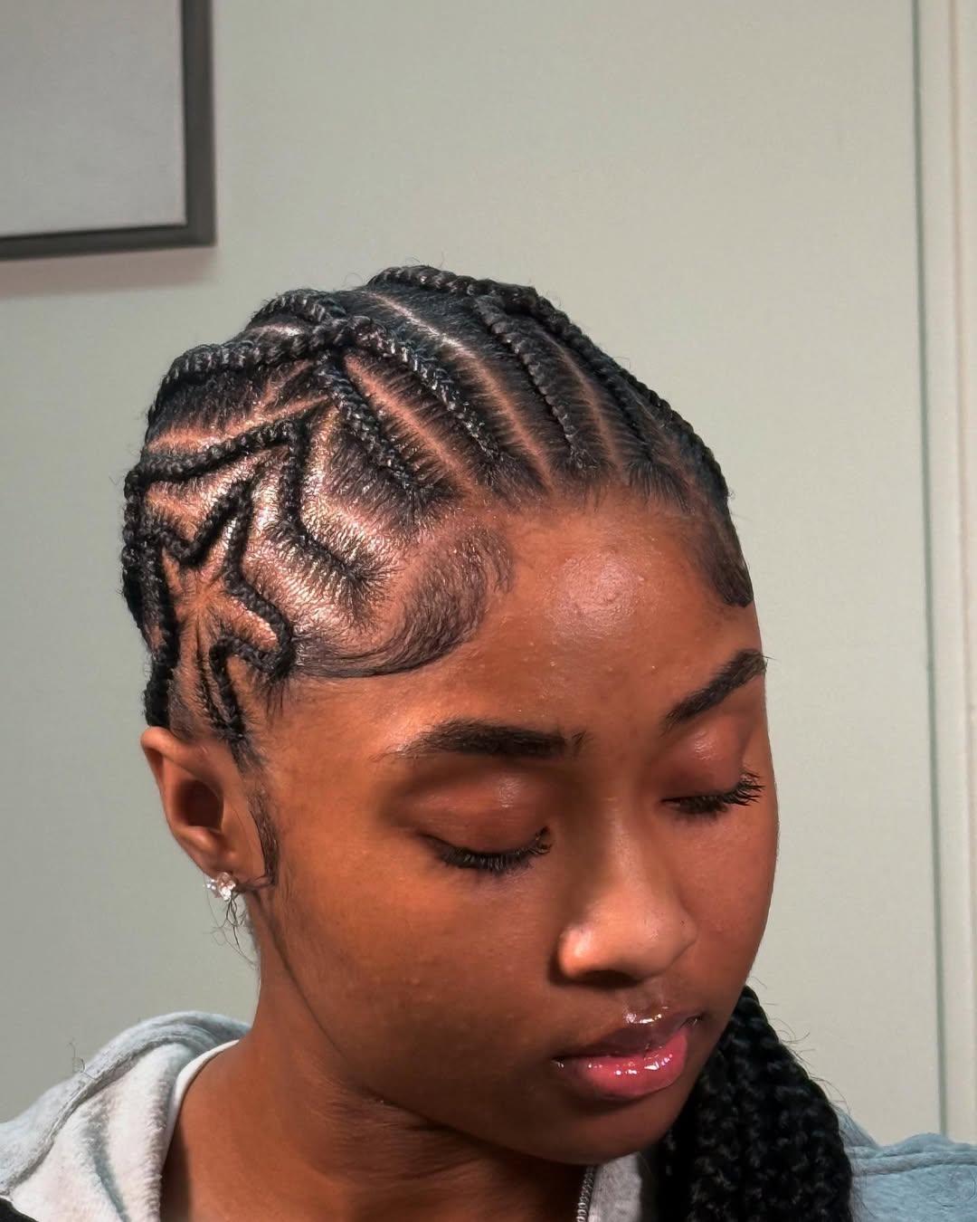 Black cornrows with zigzag designs and a long braided ponytail by Ani Braids in Lanham, Maryland
