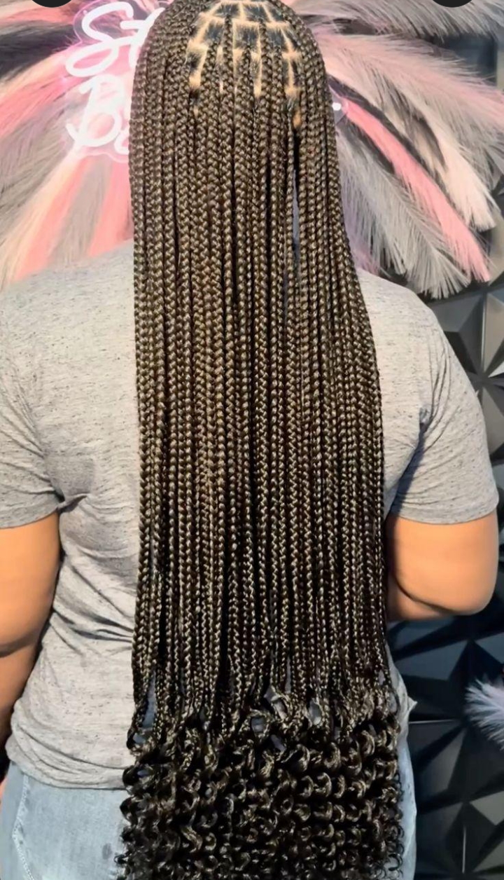 Back view of waist-length knotless braids with curly ends and clean triangle parting, styled at Ani Braids in Lanham, Maryland